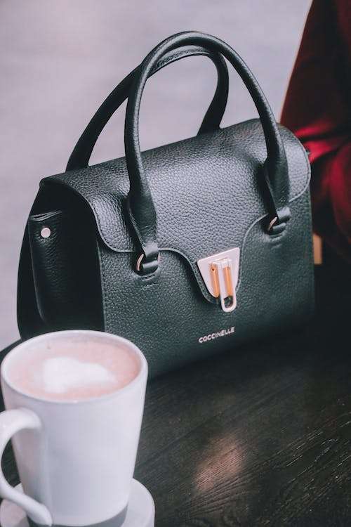Free Black Leather Handbag and a Cup of Coffee Stock Photo